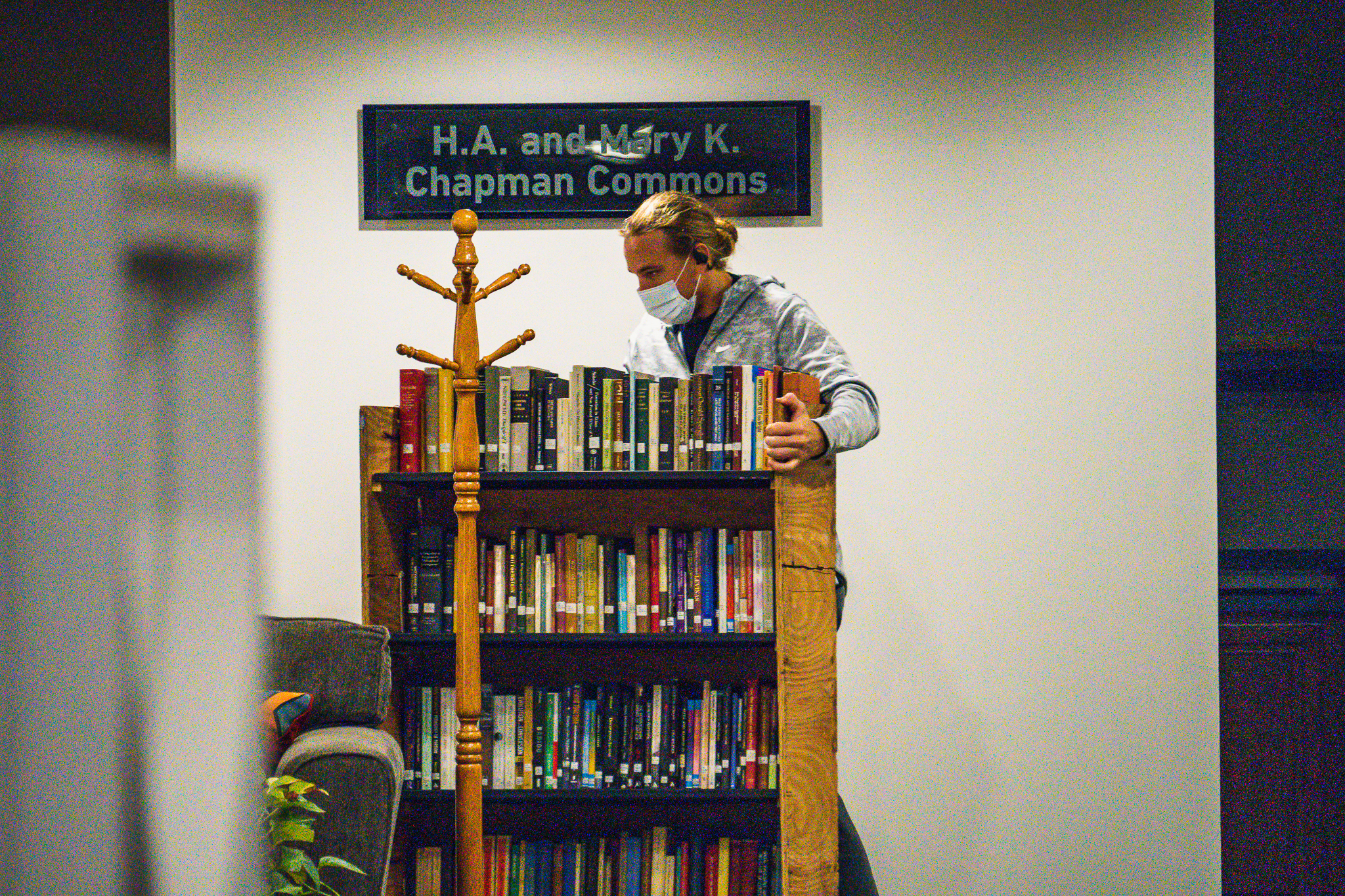 A worker moves a cart of books from the Phillips library.